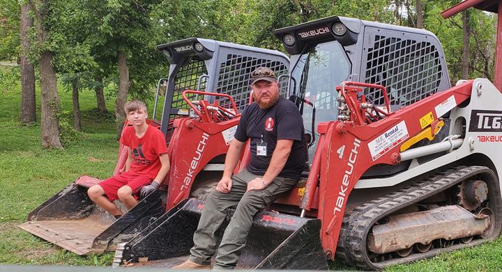 Volunteers with two compact track loaders
