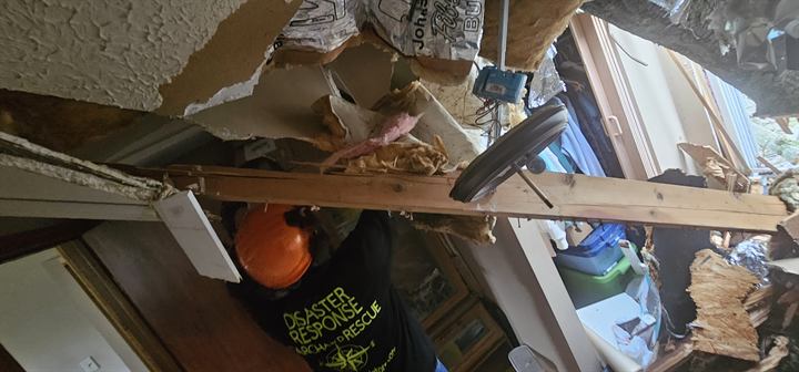 A volunteer works inside a storm-damaged home