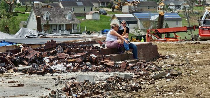 A volunteer rests among the debris of homes destroyed by the London, Kentucky tornado