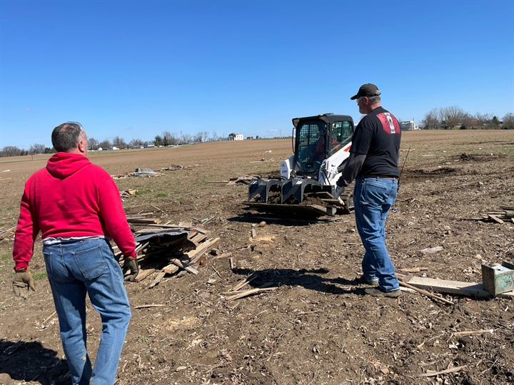 Volunteers assess a tornado-damaged field in Springfield, Ohio