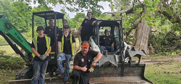 Crew members with a mini excavator and a skid steer