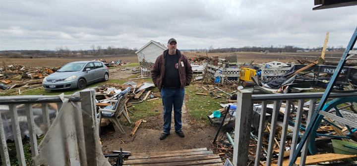 A volunteer stands amid tornado debris in Springfield, Ohio