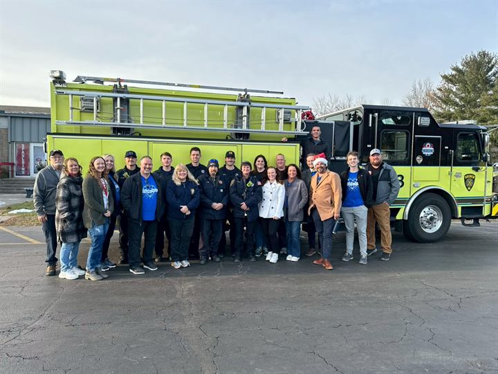 American Regulators volunteers with Goshen firefighters in front of a Goshen fire engine