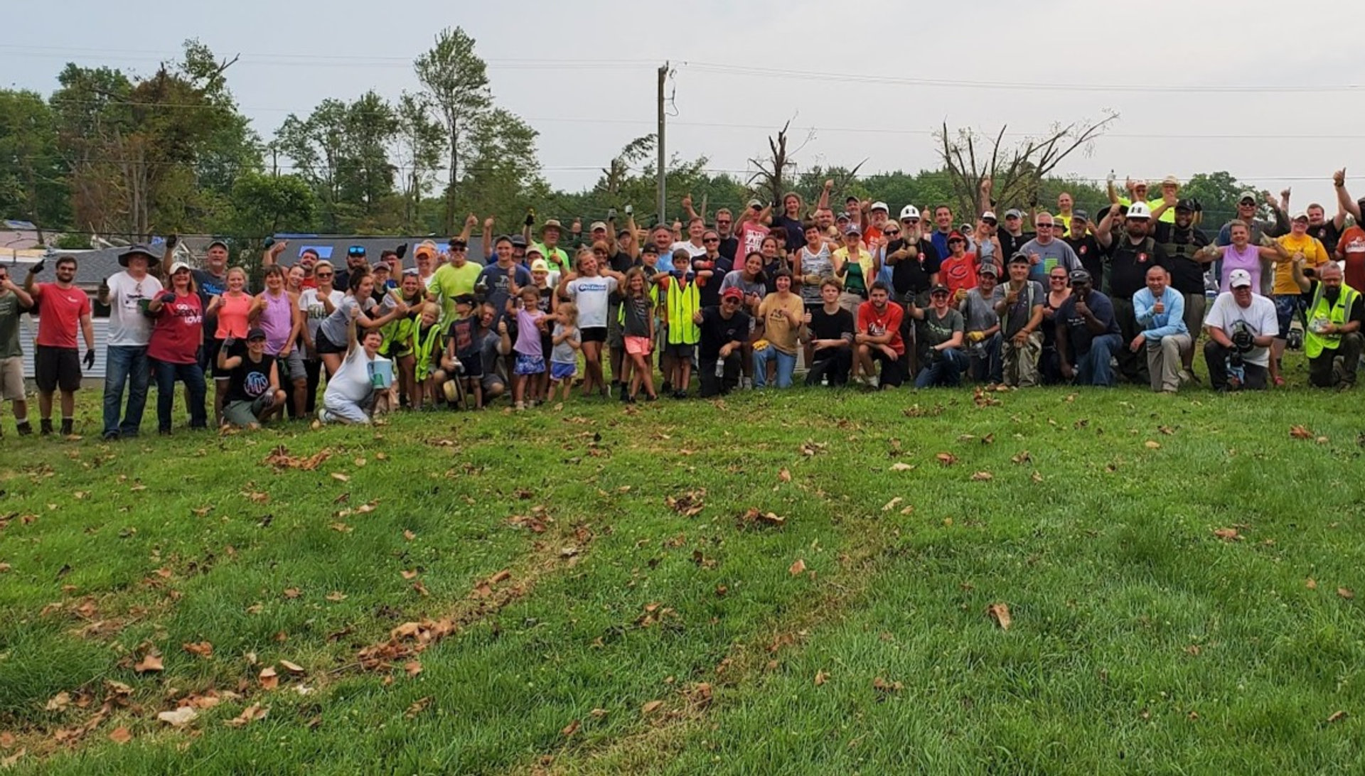 Dozens of American Regulators volunteers gathered on a field after a deployment